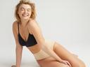 v-neck bralette - seamless in Black worn by woman sitting on ground with one hand on leg Yummie
