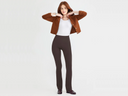 A woman is wearing the Jodi legging in Java with a white bodysuit and light brown jacket. Yummie