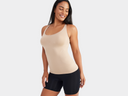 A woman is wearing the Fay Convertible Zoned Shapewear Camisole in almond with shapewear shorts in black. Yummie